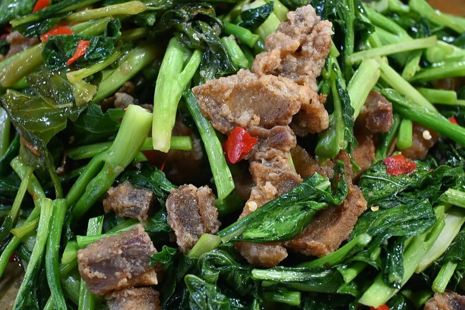 Pork stir-fry with greens and chilli in a wok sauce